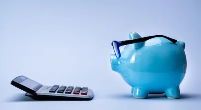 piggy bank wearing glasses looking at a calculator piggy bank wearing glasses looking at a calculator