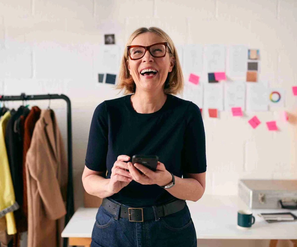 Woman Laughing While Holding A Smartphone