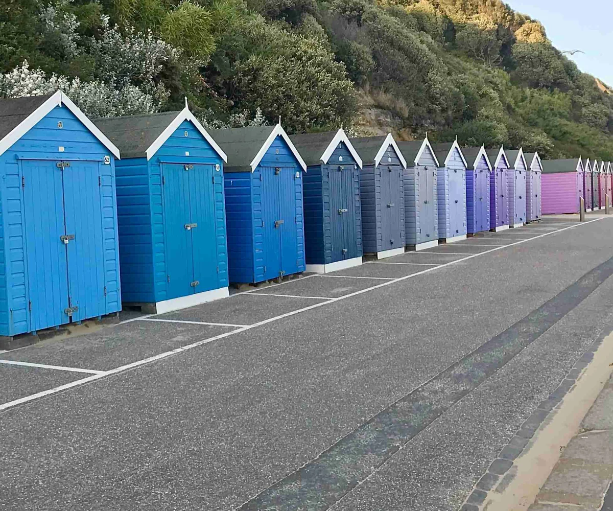 Rows Of Beach Sheds In Blue And Purple