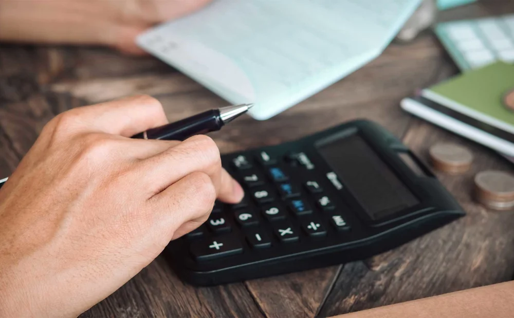 person using calculator on desk person using calculator on desk