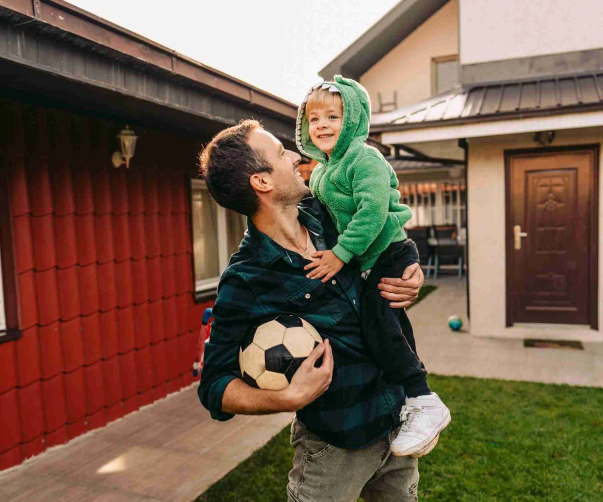 Man Holding Child With Football