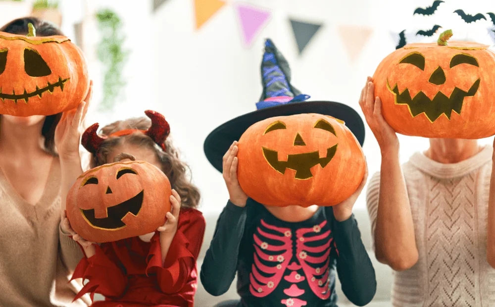 two adults and two kids holding jack o lanterns two adults and two kids holding jack o lanterns