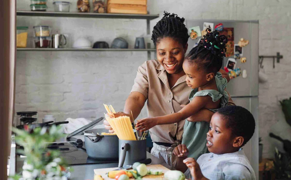 Mother Cooking Spaghetti With Two Children Mother Cooking Spaghetti With Two Children