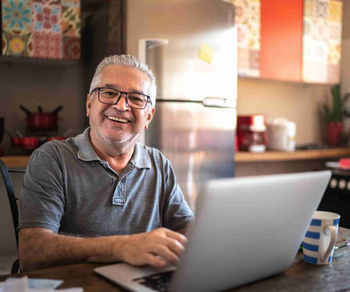 Man Smiling While Working On A Laptop