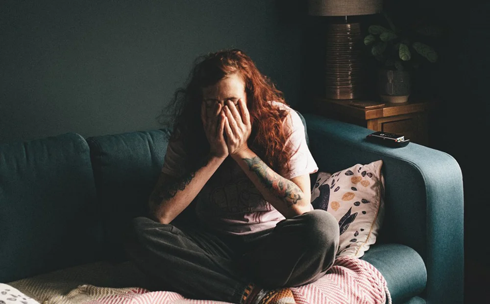 person covering face on the sofa person covering face on the sofa