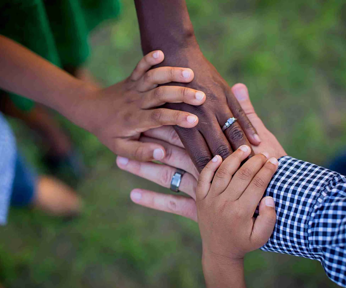 A Family Of Four Putting Their Hands In