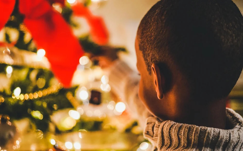 a child putting an ornament on a christmas tree a child putting an ornament on a christmas tree