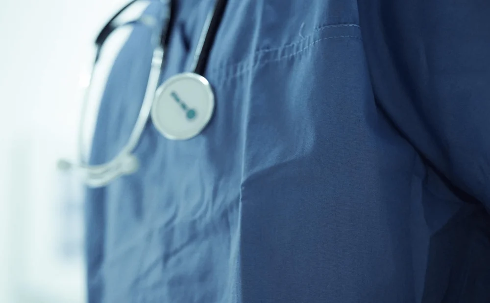 close up of person in scrubs and stethoscope close up of person in scrubs and stethoscope
