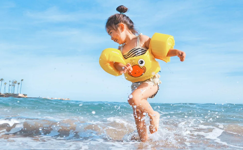 kid playing in water with duck floatie kid playing in water with duck floatie